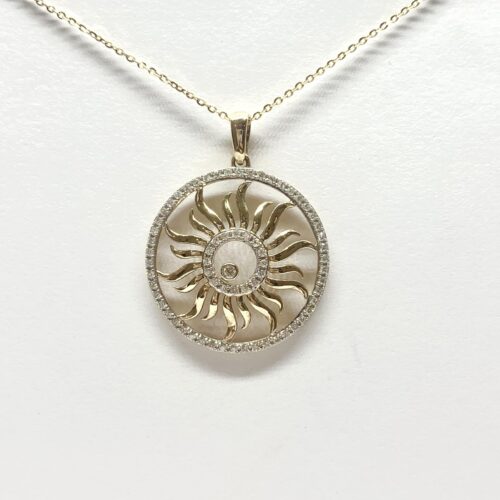 Gold pendant with a sunburst design, encircled by diamonds, on a delicate chain against a white background.