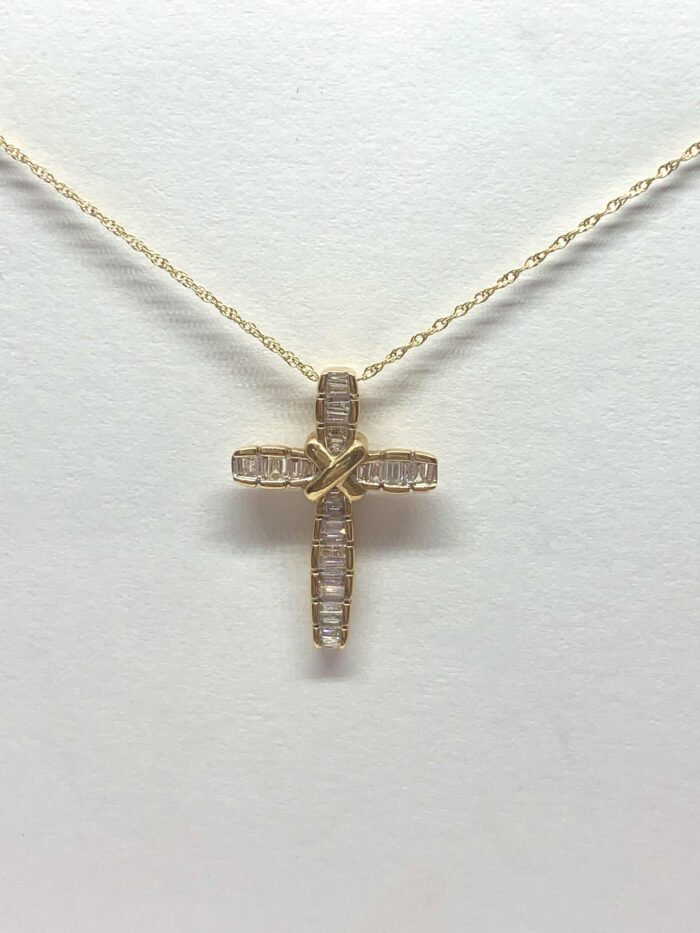 Gold cross necklace with diamonds and a twisted gold center on a chain.