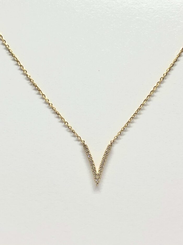 A gold necklace with a V-shaped pendant made of sparkling diamonds on a white background.