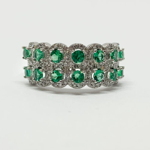 Close-up view of a white gold ring with an emerald and diamond cluster.