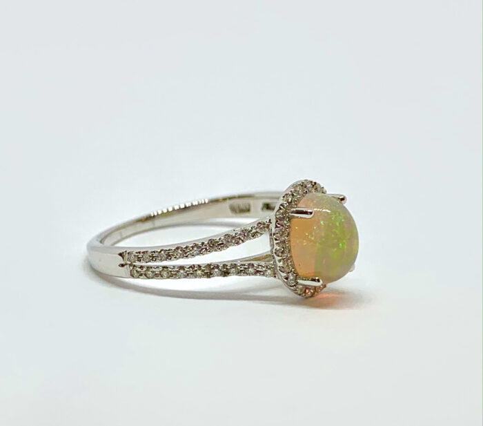 Opal ring with diamond halo on a silver band.