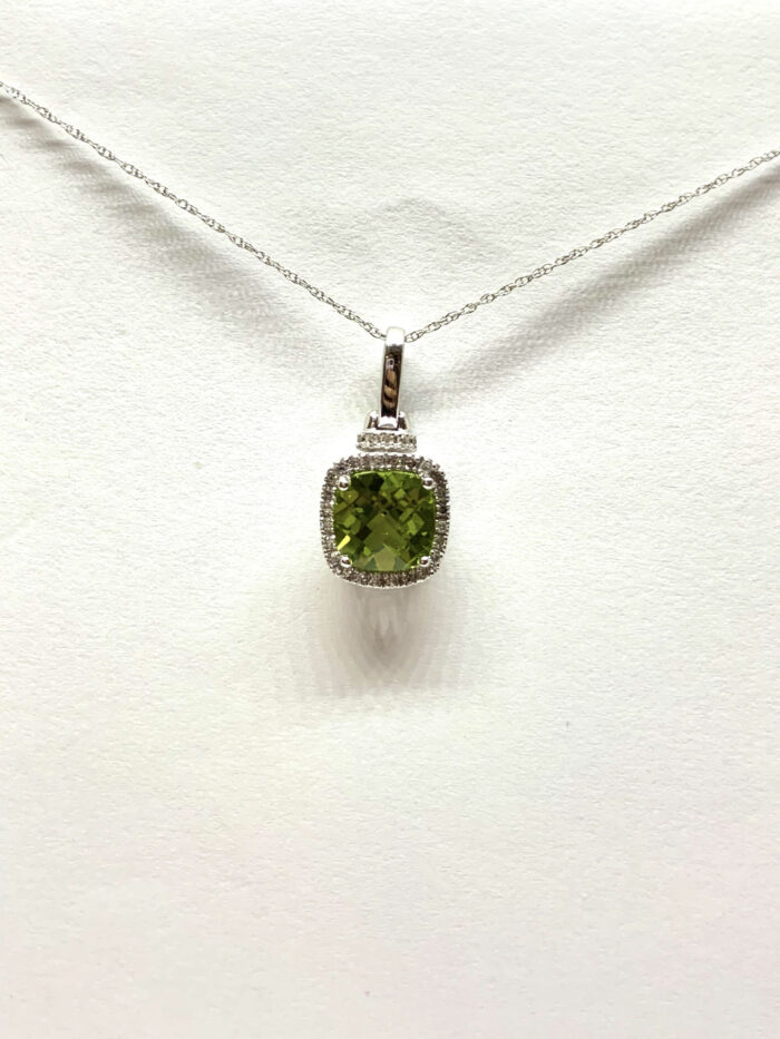 Green gemstone pendant with diamonds on a silver chain.