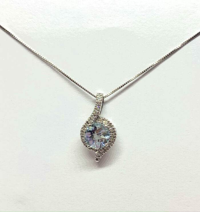 Teardrop-shaped gemstone pendant with a diamond accent on a silver necklace.