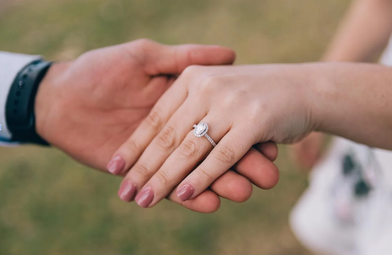 Hands joined showcasing an engagement ring