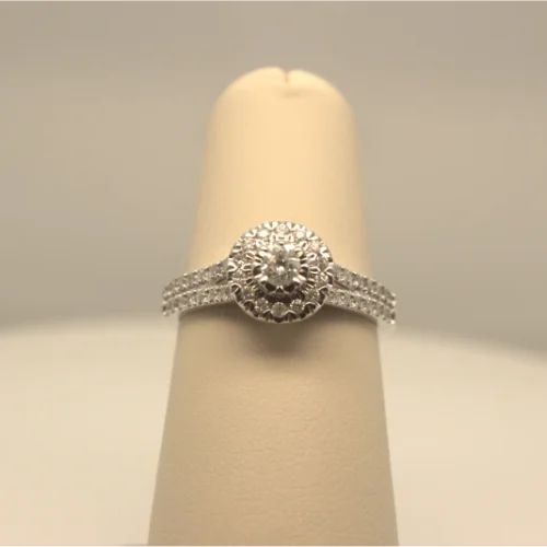 An elegant diamond engagement ring presented on a cream-colored ring display.